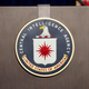 A lectern with the CIA logo on it flanked by a U.S. flag and CIA flag